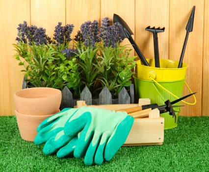 Gardener wearing PPE inspecting a strimmer before use