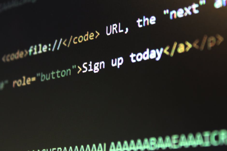 Close-up image of a laptop computer displaying a screen filled with lines of colorful programming code. The keyboard is visible in the foreground, with black keys and white lettering, and the screen s